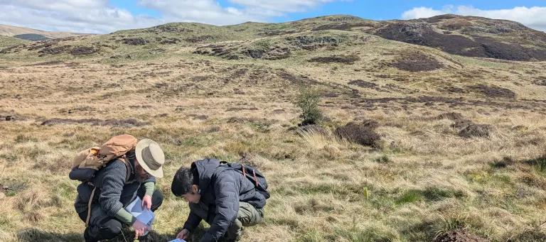 A student identifies a newly planted tree sapling at Drumbrae