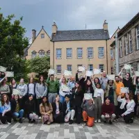 Changemakers hold certificates in courtyard