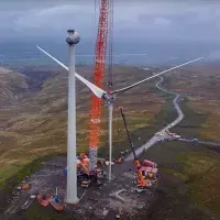 Photo showing a wind turbine being assembled with a crane.