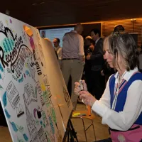 A person illustrating live on a large drawing board