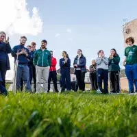 Active Lives' Amanda Marshall demonstrates how to plant a tree to a group of student athletes at Peffermill Playing Fields.