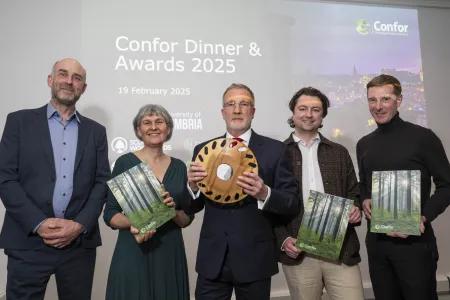 Yvonne Edwards and other people nominated for the Contribution to net Zero award standing holding certificates and trophy. 