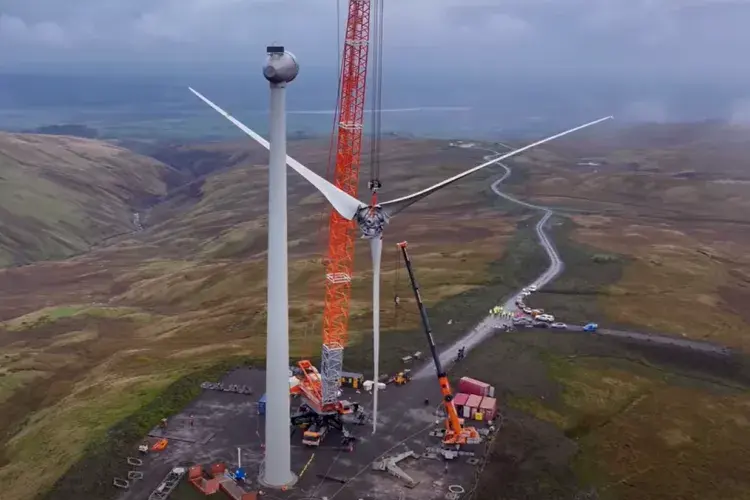Photo showing a wind turbine being assembled with a crane.