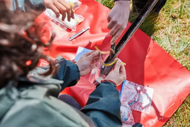 A soil sample being put into a bag.