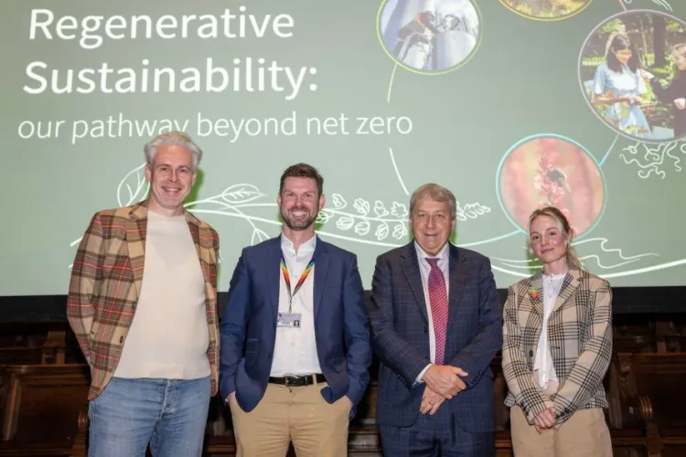 four people stand on a stage with a slide behind them that reads "Regenerative sustainability: our pathway beyond net zero"
