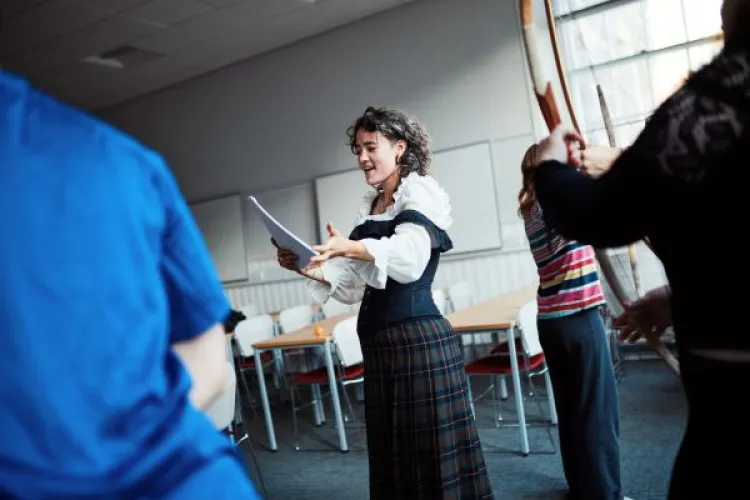 A person in costume reads from a script