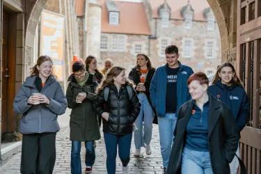 A group of people walk through an archway
