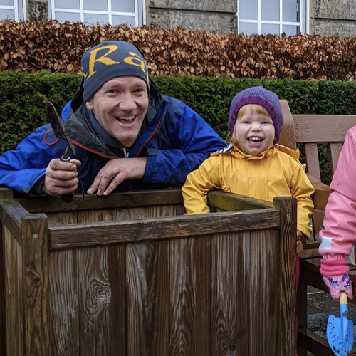 Changemaker Award 2023 - Peter Buckley - posing with child at planter, holding trowel